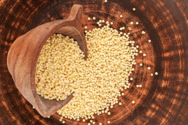Millet ahşap bir bardakta kil tabakta, makro, üst manzara.