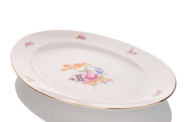 Eski bir porselen tabak, makro, beyaz arka planda izole edilmiş..