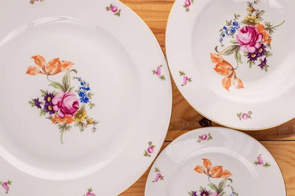 Tahta bir masada üç eski porselen tabak, makro, üst manzara..