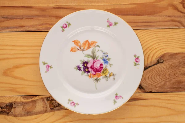 Tahta bir masada eski bir porselen tabak, makro, üst manzara..