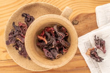 Kuru kokulu karkade çayı, seramik bardak ve ahşap masa, makro, üst manzara..