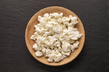 Seramik tabakta taze süzme peynir, kayrak taşı, makro, üst manzara.