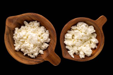 Siyah arka planda iki tahta bardakta taze peynir, makro, üst manzara..