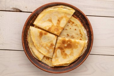 Tahta masada seramik tabağı olan birkaç tatlı krep, makro, üst manzara..