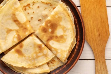 Birkaç tatlı krep seramik tabak ve ahşap masa üzerinde ahşap spatula, makro, üst manzara.