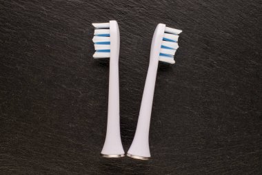 Bir elektrikli diş fırçası için iki eklenti taş, makro, üst görünüm.