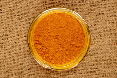 Cam kabın içindeki zerdeçal baharatı jüt bezi, makro, üst görünüm.