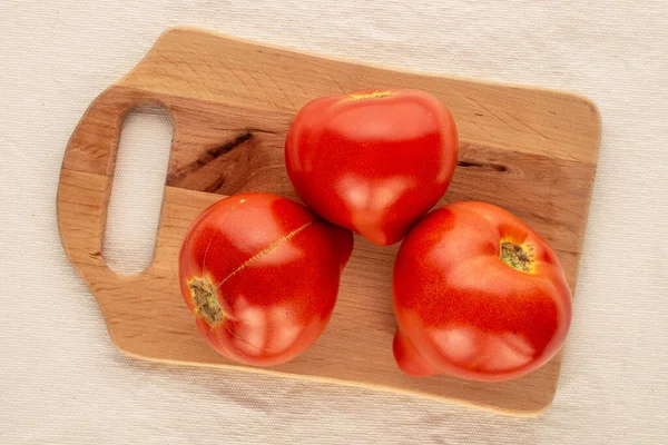 Three Red Tomatoes Wooden Kitchen Board Linen Cloth Macro Top — Stock Photo, Image