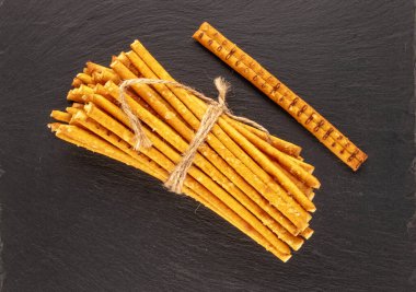 Saman bir fırın ürünüdür. Tahta bir taş üzerinde birkaç pipet, makro, üst görünüm.