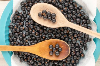 Tabaklı birkaç organik kuşüzümü, ahşap masada tahta kaşıklar, makro, üst manzara..