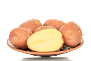 Bir sürü pembe, çiğ patates ve yarım kilden bir tabak, makro, beyaz arka planda izole edilmiş..