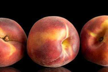 Üç olgun organik şeftali, makro, siyah arka planda izole edilmiş..