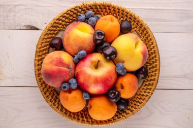 Tahta masadaki seramik tabakta taze tatlı meyveler, makro, üst manzara..