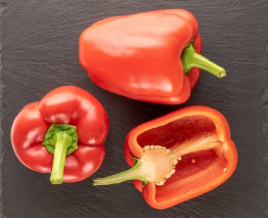 İki tam ve bir buçuk tatlı kırmızı biber taş üzerinde, makro, üst manzara.