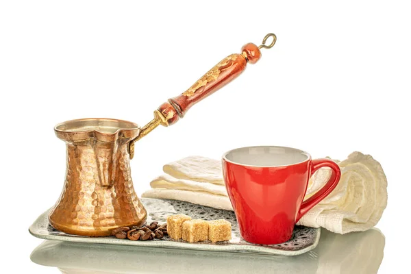 One cezva with a ceramic cup, sugar and some coffee beans on a ceramic tray, macro, isolated on white background.