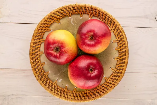 木桌上有三个有陶瓷盘的有机多汁苹果 宏观上视图 — 图库照片
