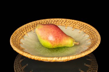 Seramik tabakta güzel kokulu bir armut, makro, siyah arka planda izole edilmiş..