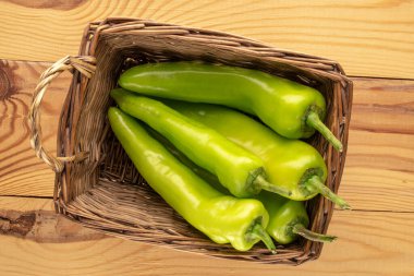 Ahşap bir masada sepetin içinde yeşil biber, makro, üst manzara..