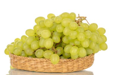 Saman tabaktaki tatlı çekirdeksiz üzümler, makro, beyaz arka planda izole edilmiş..