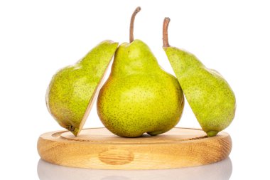 Olgun bir armutun iki yarısı ve beyaz arka planda izole edilmiş, ahşap bir tepside bir bütün..