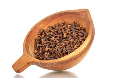 Tahta bir fincanda kuru aromatik karanfiller, makro, beyaz bir arka planda izole edilmiş..