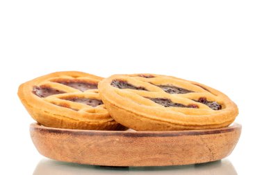 Beyaz arka planda izole edilmiş, ahşap bir çay tabağında reçelli iki kurabiye..