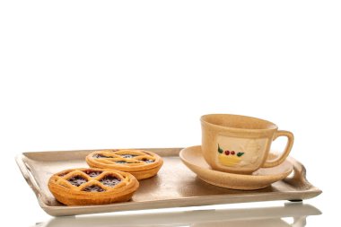 Metal tepside reçelli iki kurabiye seramik fincan ve fincanla, makro, beyaz arka planda izole edilmiş..