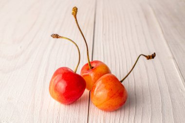 Tahta bir masada üç tatlı kiraz meyvesi, makro..