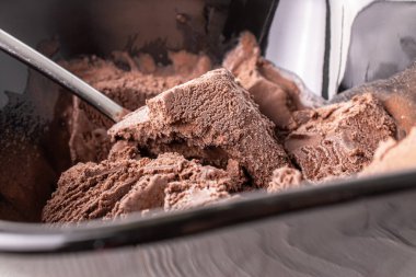 Seramik tabakta çikolatalı dondurma, tahta bir masada metal kaşık, makro..