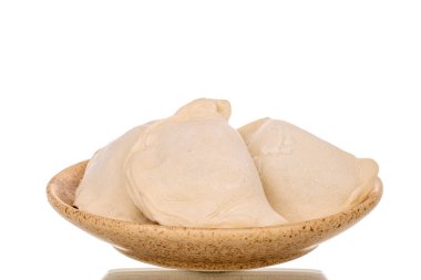 Beyaz arka planda izole edilmiş, seramik tabakta yarı bitmiş birkaç hamur köftesi..