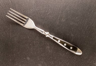 Taş üzerinde bir metal çatal, makro, üst görünüm.