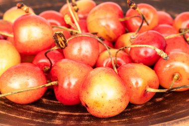 Organik olgun kiraz böğürtlenleri bir kil tabağında.
