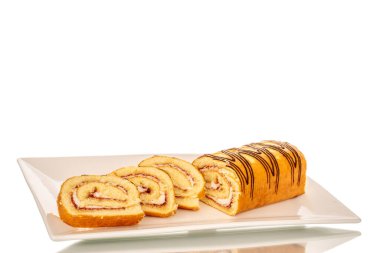 Beyaz arka planda izole edilmiş beyaz seramik bir tabakta dilimlenmiş lezzetli bir kiraz rulosu..