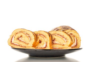 Beyaz arka planda izole edilmiş, seramik bir tabakta dilimlenmiş lezzetli bir kiraz rulosu..