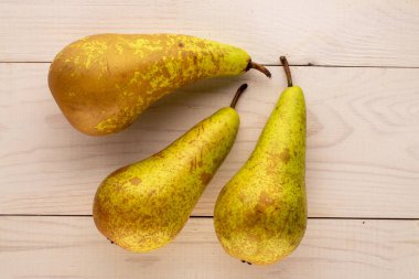 Tahta bir masada üç olgun armut, makro, üst manzara..