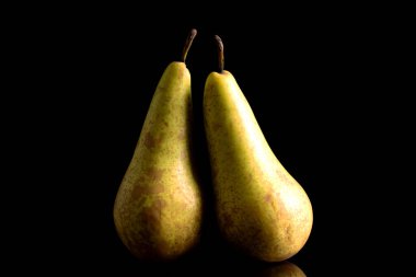 İki olgun armut, makro, siyah arka planda izole edilmiş..