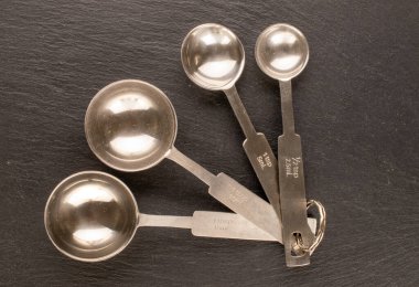 Tahta taş, makro ve üst görünüm üzerindeki gevşek nesneleri ölçmek için birkaç metal kaşık..