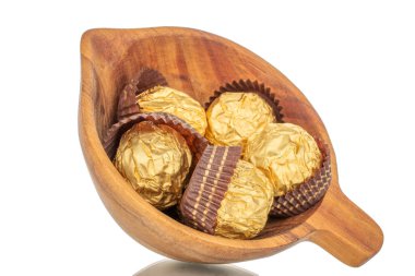 Tahta bardakta, fındıklı çikolata şekerlemeleri, yakın plan, beyaz arka planda izole edilmiş..