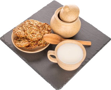 Beyaz arka planda izole edilmiş birkaç Thaler kurabiyesi, bir fincan ekşi krema ve bir şeker kasesi, makro..