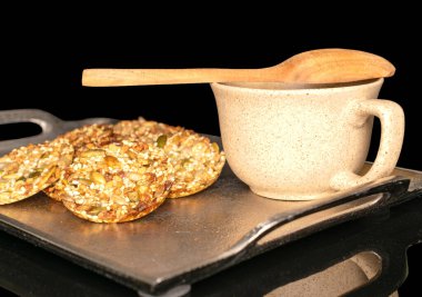 Metal tepside seramik bardaklı birkaç tatlı taler kurabiyesi, makro, siyah arka planda izole edilmiş..