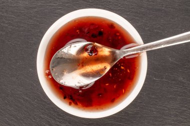 Beyaz seramik tabakta çilek reçeli, metal kaşık, makro, üst manzara..