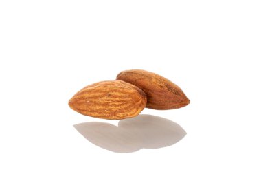 İki kavrulmuş badem, makro, beyaz arka planda izole edilmiş..