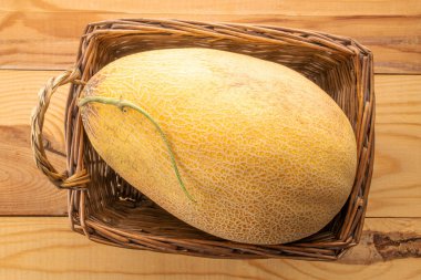 Tahta bir masada sepetin içinde olgun bir kavun, makro, üst manzara..