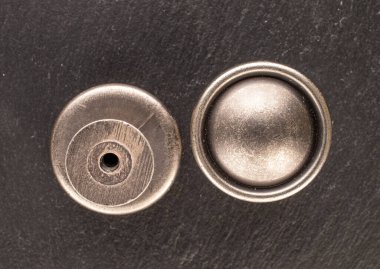 Kayrak taşı üzerinde iki metal çekmece tutacağı, mobilya aksesuarları, makro, üst görünüm.