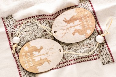 Wooden decoration for Easter on an embroidered towel, macro, top view. clipart