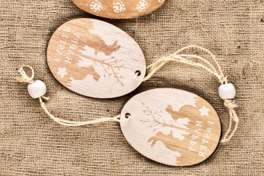 Wooden decoration for Easter on jute cloth, macro, top view. clipart