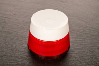 Bir cam kavanoz yüz kremi kayrak taşında.