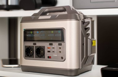 Evrensel bir elektrik bataryası, taşınabilir bir şarj istasyonu aletlerle dolu bir masada duruyor..