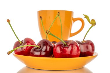 Beyaz zemin üzerinde izole edilmiş, seramik fincan ve çay tabağı, makro ile birkaç tatlı kiraz..