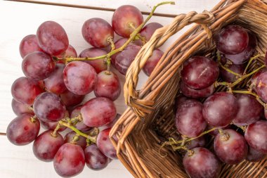 Tahta masadaki sepetin içinde olgun üzümler, makro, üst manzara..